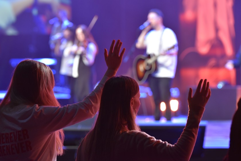 Zwei Frauen vor Bühne der Revive Europe von der International Fellowship of Evangelical Students (IFES)