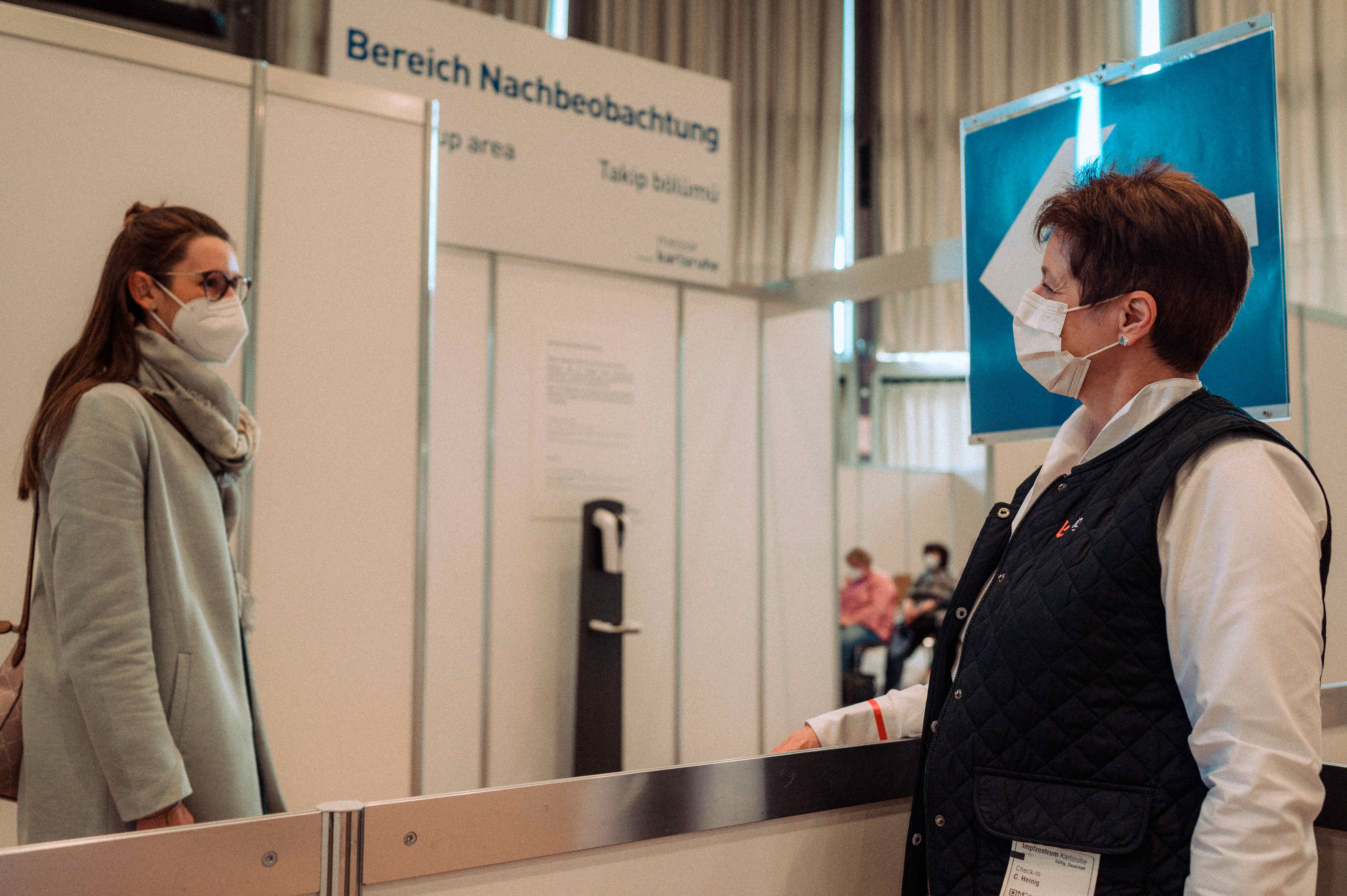 Eine Impfwillige bespricht sich mit einer Messearbeiterin. Messe Karlsruhe als Impfstandort