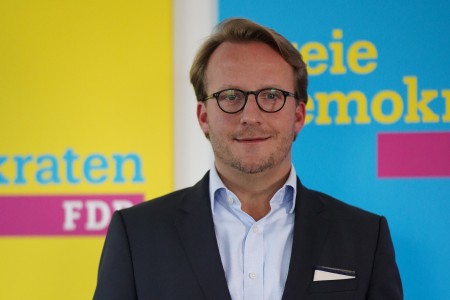 Bild eines Mannes vor einer FDP-Rückwand