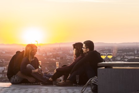 Junge Menschen machen ein Picknick bei Sonnenuntergang auf der Turmbergterasse 